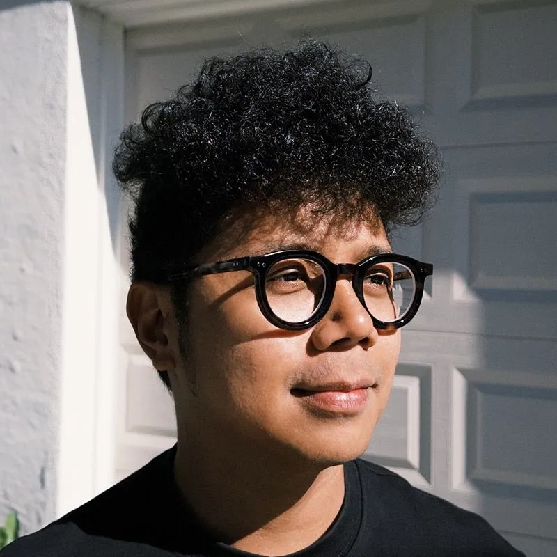 My headshot wearing dark glasses and a black shirt, looking to the left