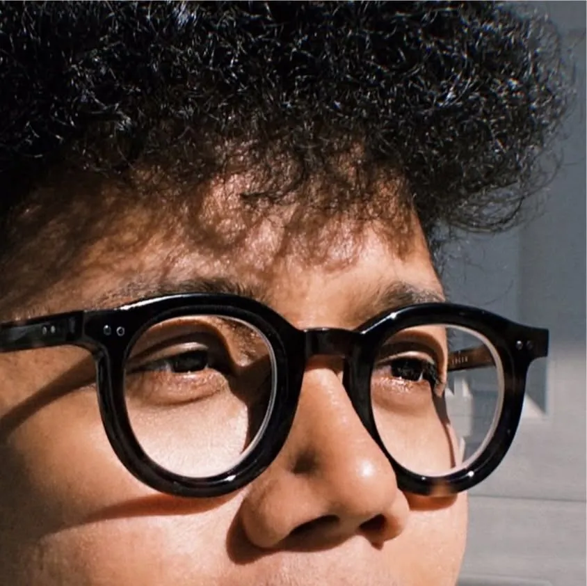 My headshot wearing dark glasses and a black shirt, looking to the left